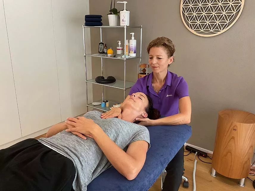 Eine Frau erhält eine Massage in einem Raum. Physiotherapie mit Craniosacral Therapie. Eine Frau erhält eine Massage in einem Raum. Physiotherapie mit Craniosacral Therapie.