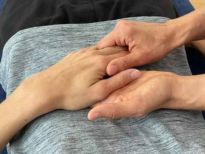 Eine Physiotherapeutin hält die Hand einer anderen Person. Jin Shin Jyutsu - eine heilende Berührung. Eine Physiotherapeutin hält die Hand einer anderen Person. Jin Shin Jyutsu - eine heilende Berührung.